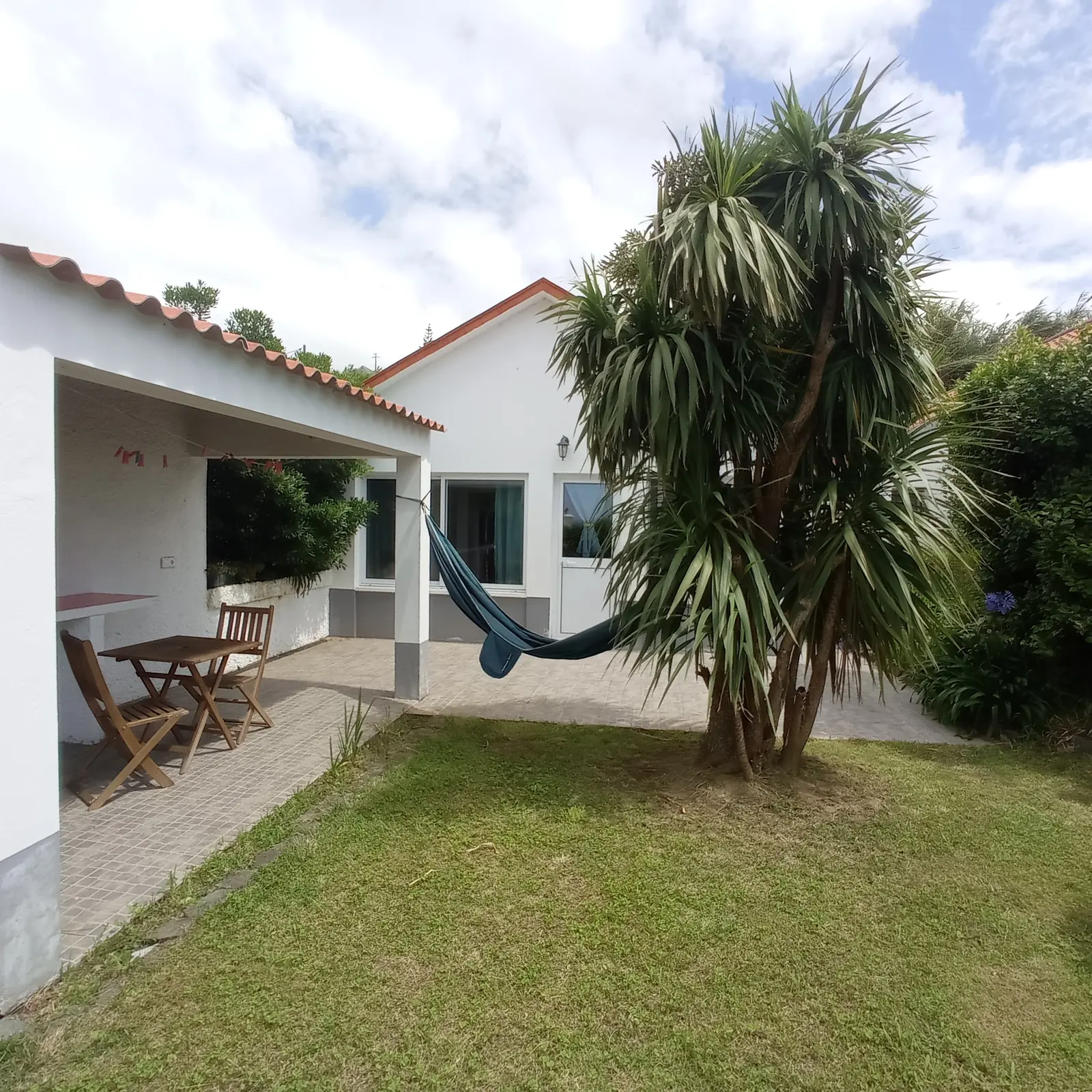 Casa Esmeralda: Haus mit überdachter Terrasse, Palme und Rasen
