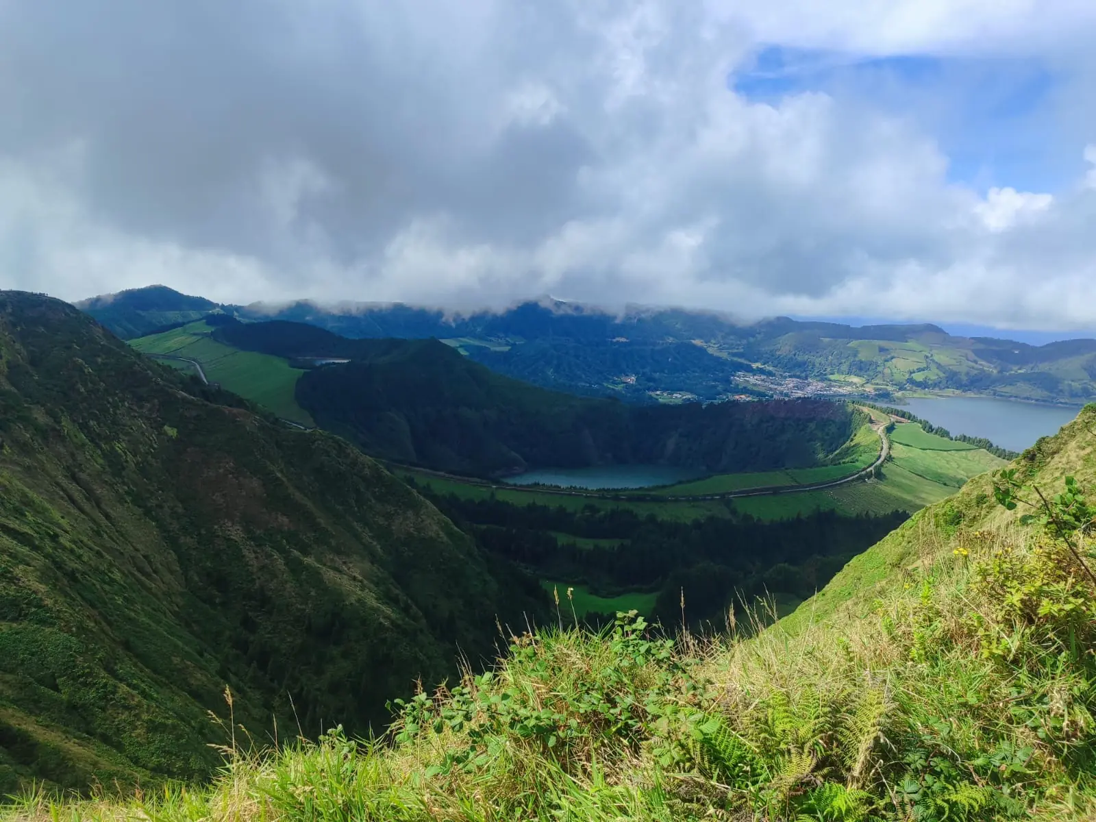 Blick in einen grünen Krater mit See