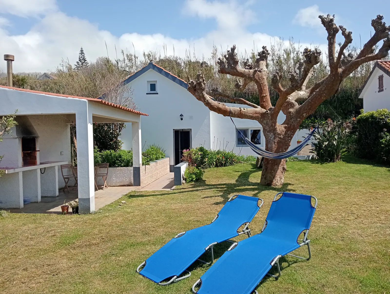 Casa Safira: Garten mit Sonnenliegen und weißem Haus